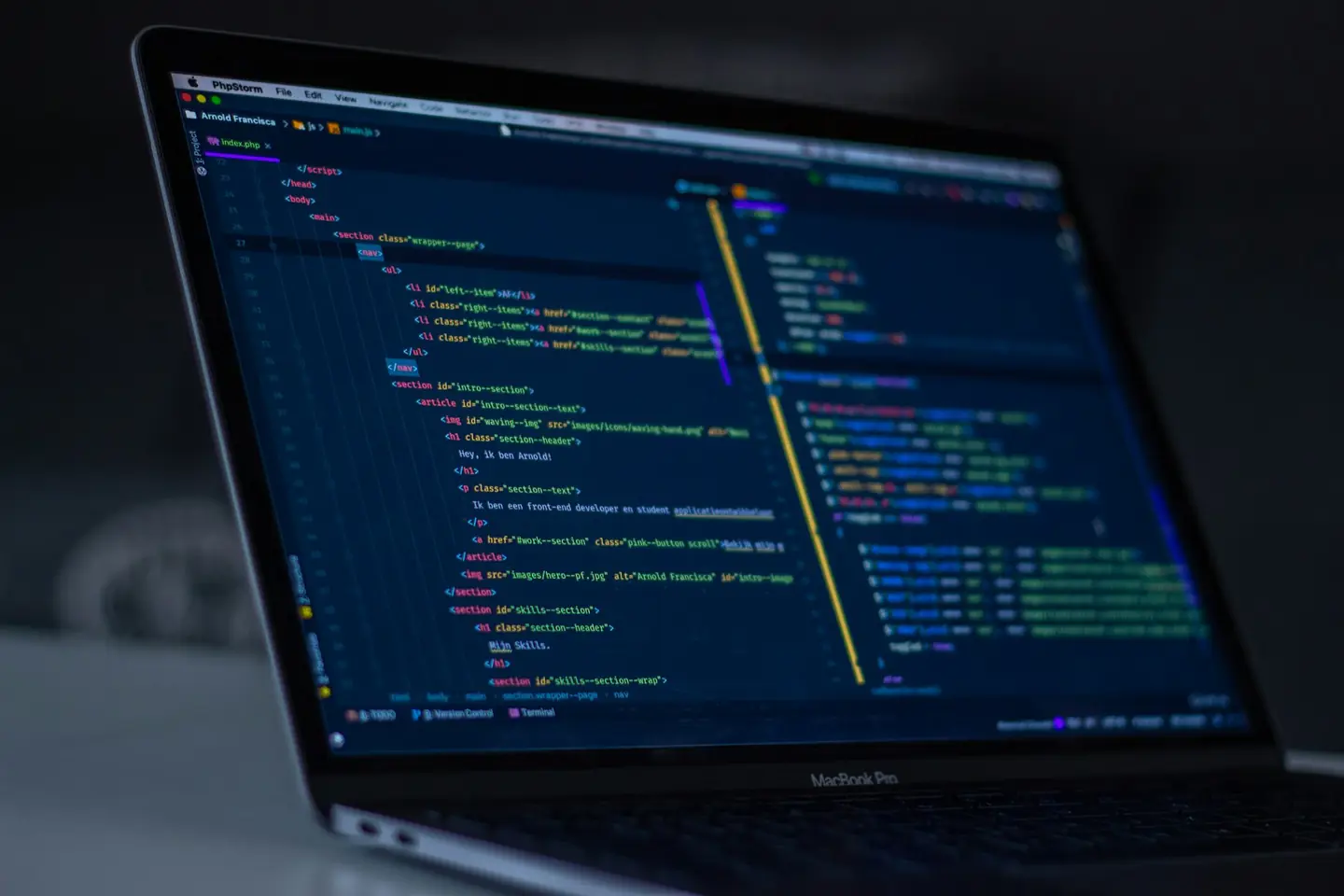 Code on a laptop screen in a dark room