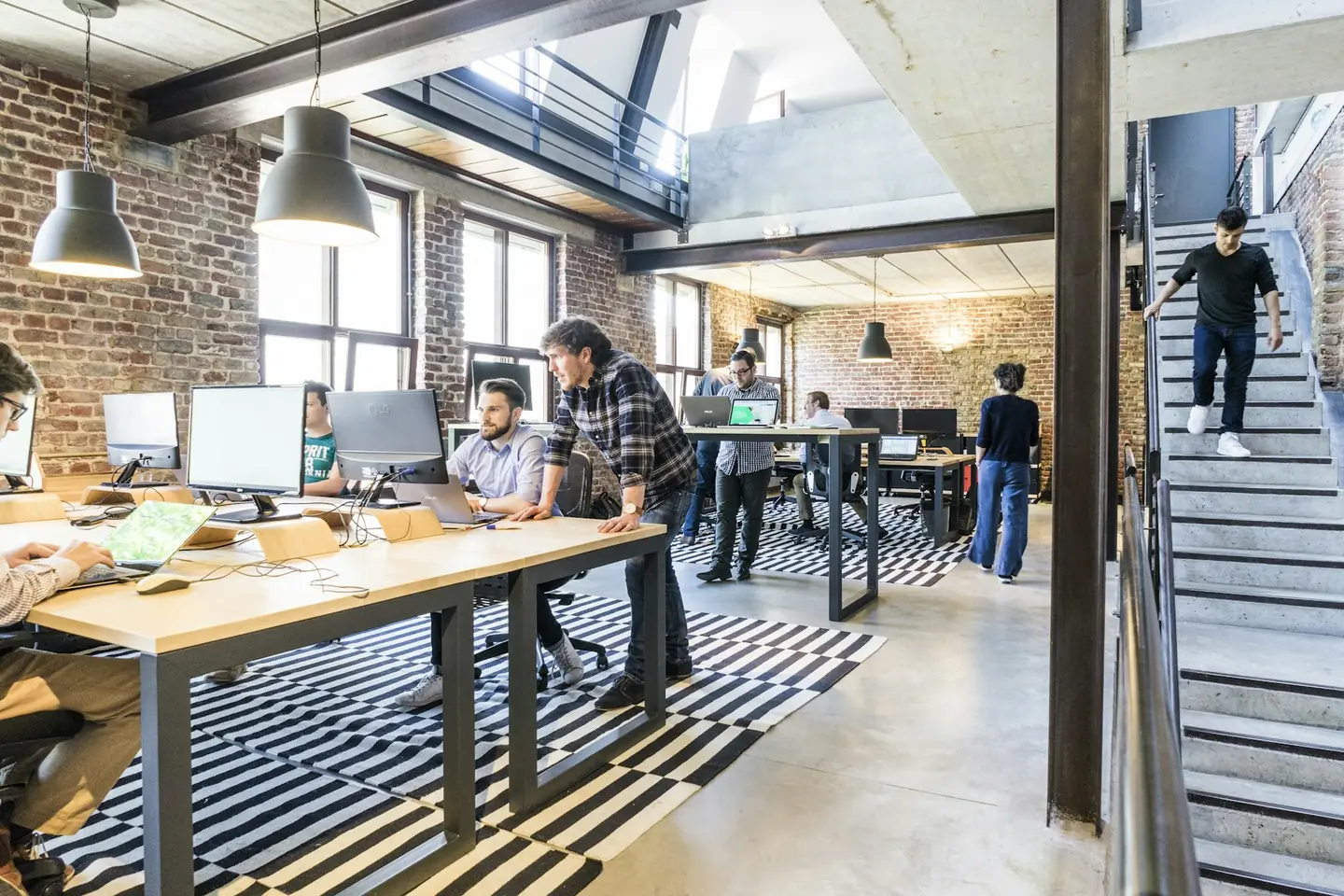 Open-plan office with long shared desks and natural light