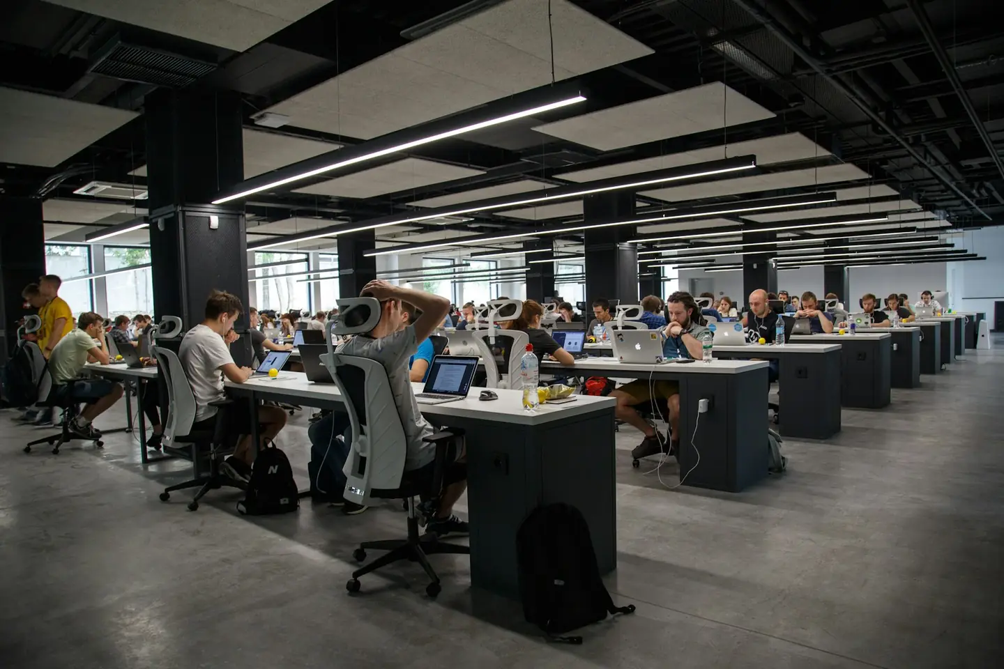 Large open-plan office with rows of desks and people working