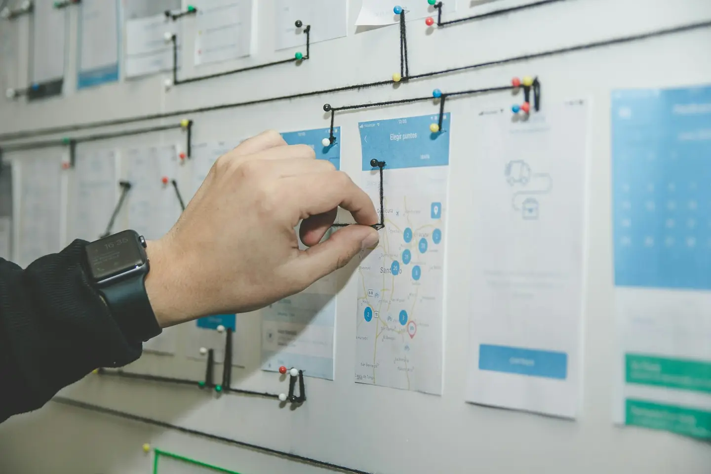 Hand pinning a printed analysis to a planning wall