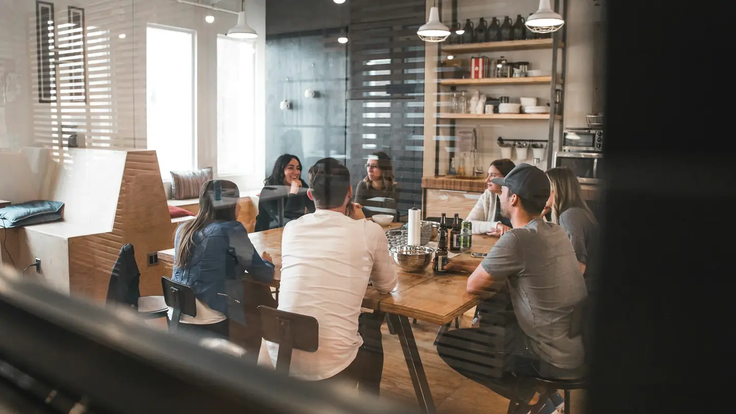People working on laptops in a busy café-style office
